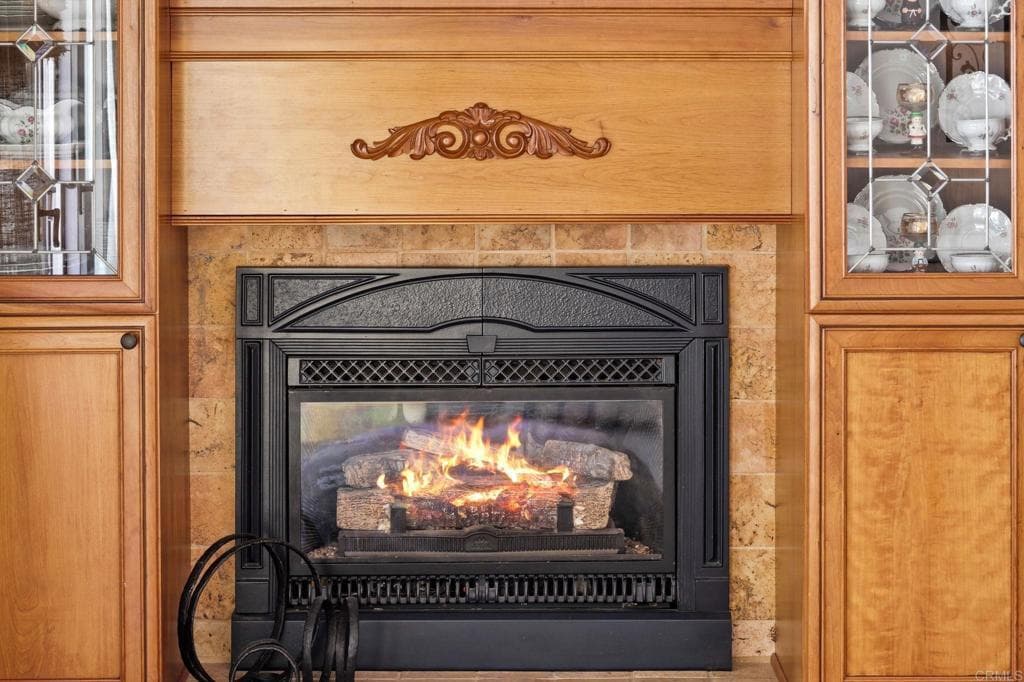 Book-matched marble and walnut built-ins frame the hearth (as-is)