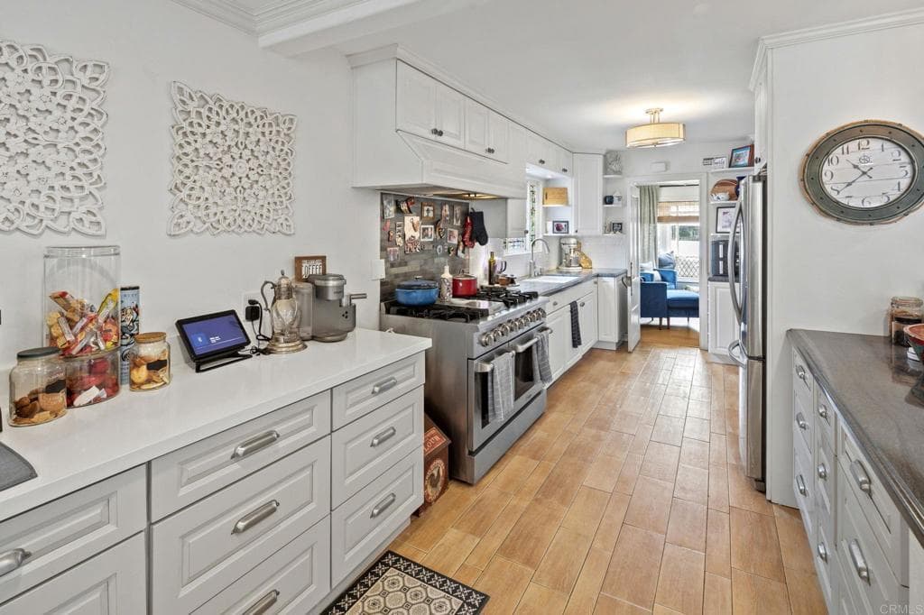 Walnut cabinetry and marble counters in a chef's galley (as-is)
