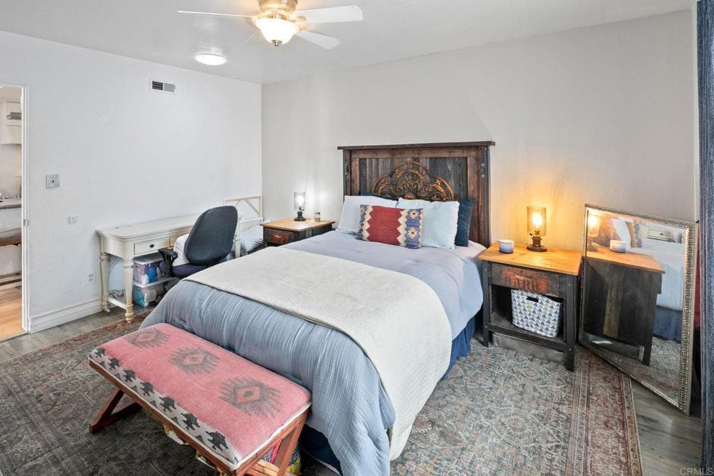 A serene primary suite with walnut nightstands and cove lighting (as-is)